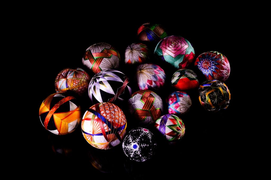 Colorful traditional Japanese Temari balls with intricate embroidery on a black background