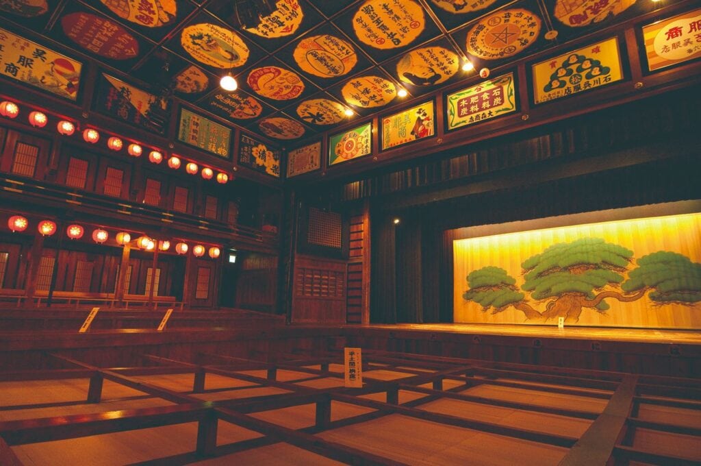 Interior of Yachiyoza Theater in Yamaga, with tatami seating and traditional painted stage